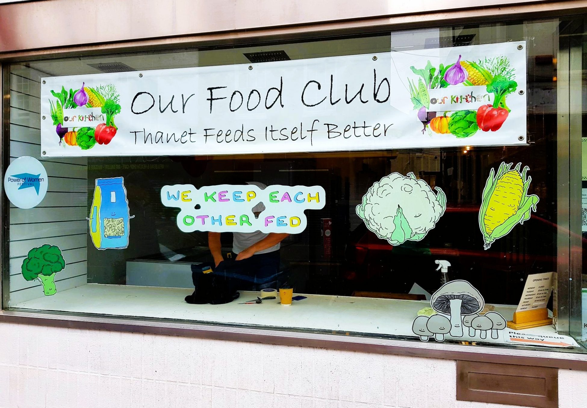 Photo of a shop unit front window, with a large banner reading 