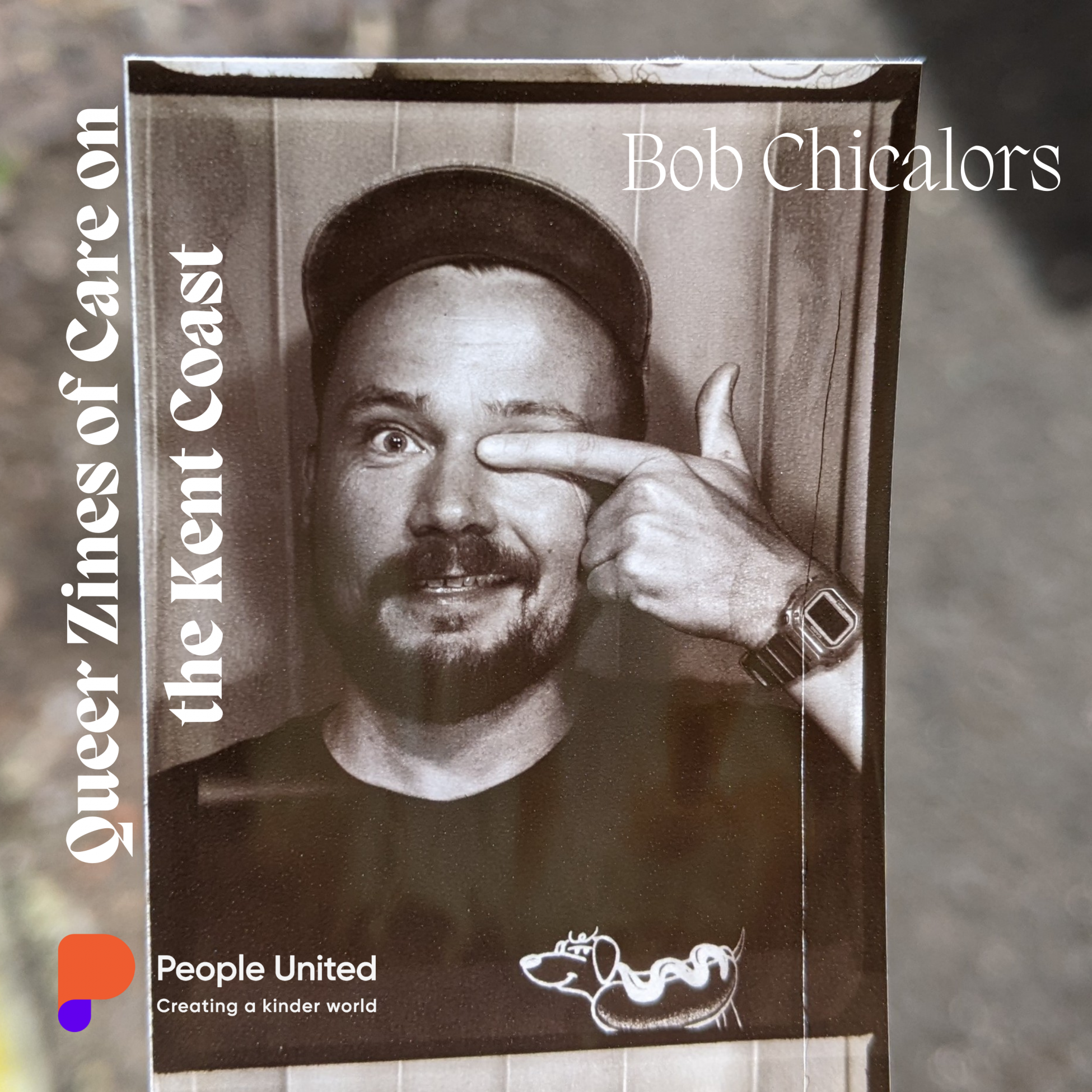A black and white picture of picture of a white man with a moustache and beard covering his eye with his finger. The man is wearing a black t-shirt with a drawing of a sausage dog in a hotdog bun. On the picture the logo of people united is on the bottom left-hand side and the words Queer Zines of Care on the Kent Coast are written on the side in white writing.